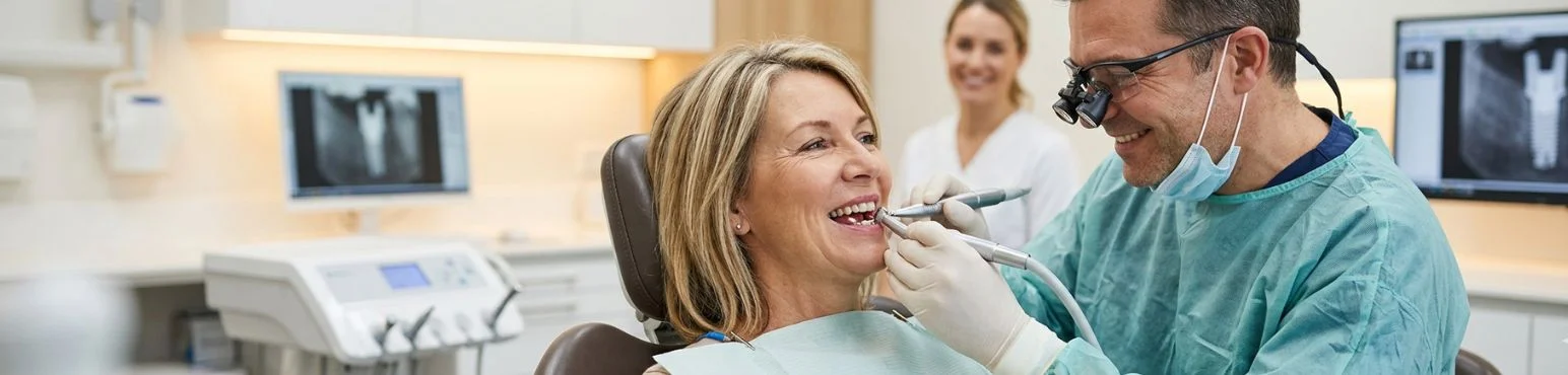 Dentist performing dental implant procedure on female patient at Parkside Drive Dental in Waterloo, ON